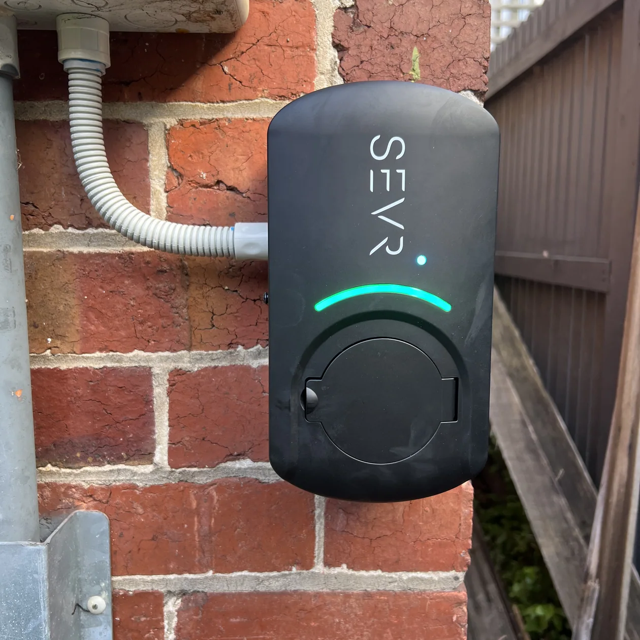 Home EV charger installed on the external wall of a house